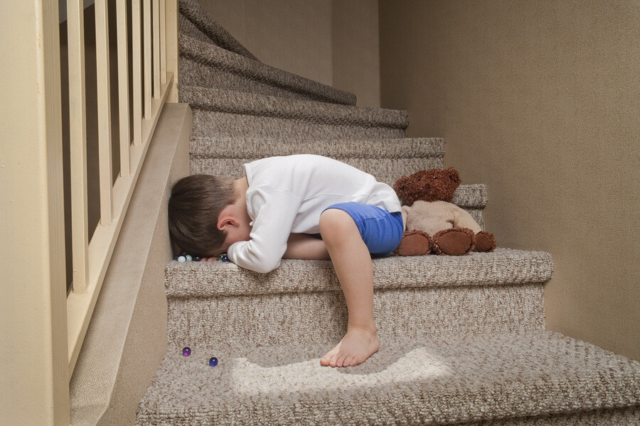 Crying boy laying on stairs