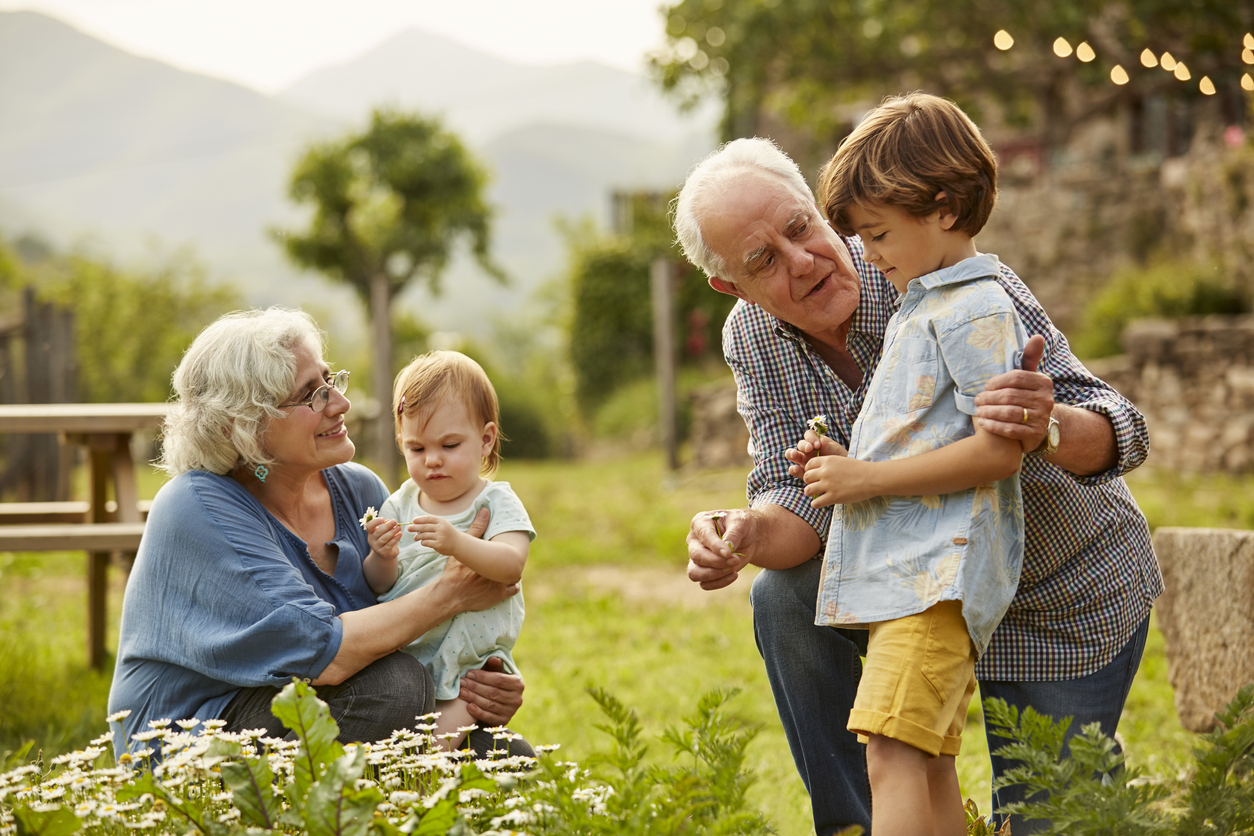 Grandparents gardening with their grandkids, having serious conversation