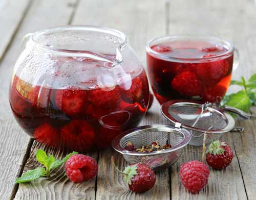 té rojo de bayas de frutas en una mesa de madera